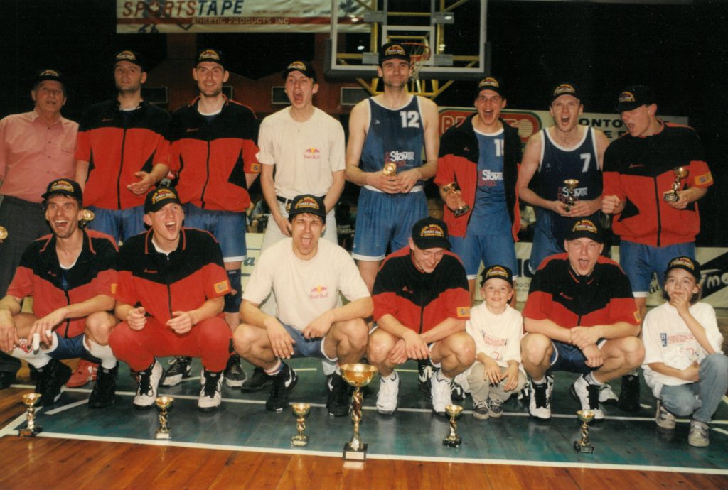 V zadní řadě první zleva v čepici mistra národní basketbalové ligy jako asistent trenéra Stavexu Brno. Hala USK Praha 1996 po vítězné finálové sérii.
